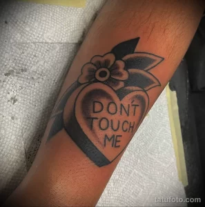 Фото тату с изображением сердца с надписью 'Don't Touch Me' и цветком на руке. Лаконичный рисунок татуировки.