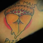 Фото тату на руке: минималистичный рисунок куска пиццы с надписью 'Comer Mais Pizza', выполненный в ярких цветах.