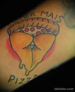 Фото тату на руке: минималистичный рисунок куска пиццы с надписью 'Comer Mais Pizza', выполненный в ярких цветах.