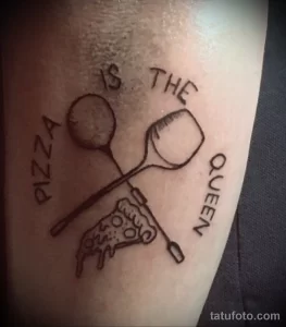 Фото тату: контурный рисунок кусочка пиццы с надписью "PIZZA IS THE QUEEN", расположенный на руке.