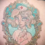 татуировка мультяшная медсестра с большими глазами в рамке нанесена на правую лопатку женщин - tatufoto.com 110223 - 158