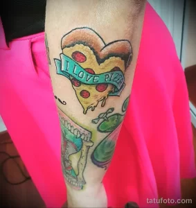 Фото тату кусочка пиццы в форме сердца с надписью 'I LOVE PIZZA', выполненное в ярких цветах на руке. Романтичный и аппетитный эскиз тату.