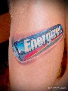 Фото тату батарейки Energizer на руке. Реалистичный рисунок с яркими цветами и четкими контурами. Идеально для любителей бренда.