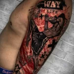 Фото реалистичной татуировки на руке, изображающей бойца Муай Тай в момент удара. Использованы черные и красные оттенки для создания драматичного эффекта.