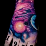 цветной рисунок татуировки с космосом на кисти правой руки и цифры 1975