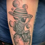 чёрно-белый рисунок татуировки Космонавтов скафандре сидит на планете