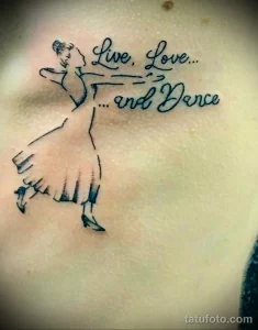 Фото тату на груди с изображением силуэта балерины и надписью "Live, Love... and Dance". Простой и элегантный дизайн.