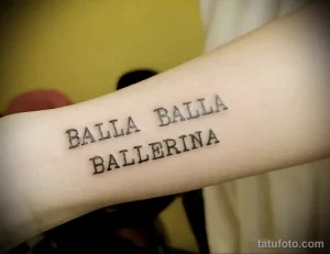 Фото тату с надписью 'Balla Ballerina' на предплечье, выполненной черными чернилами в минималистичном стиле. Идеально для любителей танцев.