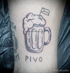 Фото татуировки на предплечье с изображением кружки пива и надписью 'PIVO'. Черно-белый рисунок в стиле эскиза с простыми линиями и минималистичным дизайном.