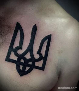Фото тату: простой и лаконичный черный трезубец Украины на груди. Минималистичный рисунок татуировки.