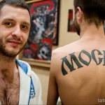 Фото тату на спине, изображающее надпись "Москва" выполненную в классическом стиле. Четкий и лаконичный рисунок татуировки.