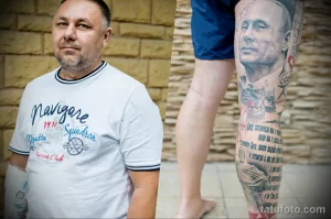 Фото тату на ноге, изображающее портрет Иосифа Сталина. Детализированный рисунок татуировки с использованием черно-белой гаммы и реалистичной проработкой деталей.
