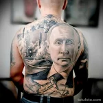 Фото татуировки на спине, изображающей портрет мужчины, Кремль, карту мира и другие символы власти и величия.