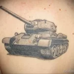 Фото тату на плече с изображением советского танка Т-34. Детализированный черно-серый рисунок татуировки в стиле реализм.