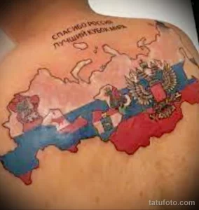 Фото тату: татуировка карты России на спине, выполненная в ярких цветах с изображением герба и флага. Символ патриотизма и любви к Родине.