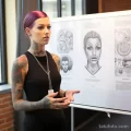 A beautiful woman with tattoos is displaying information about the likelihood of developing keloid scars, melanoma, or 2 09112023 tatufoto.com 023