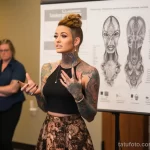 A beautiful woman with tattoos is displaying information about the likelihood of developing keloid scars, melanoma, or 4 09112023 tatufoto.com 025