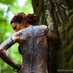 A woman revealing an intricate tattoo of an ancient tree on her side, while hiking in a majestic forest 3 - 07,11,2023 tatufoto.com