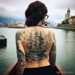 Фото тату на спине: детализированное изображение старинного парусника в бушующем море, выполненное в черно-серых тонах с добавлением легких оттенков.