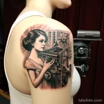Artistic tattoo of a vintage movie projector on someone's shoulder_1 16.11.2023 tatufoto.com 02