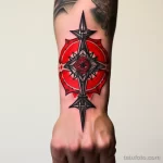 Татуировка компаса на запястье, выполненная в стиле Blackwork с использованием черных линий и красных акцентов.