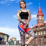 Фотография девушки с яркими татуировками на ногах и руках, демонстрирующими ее смелый и современный стиль.