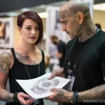 beautiful woman with tattoos is showing a man with tattoos about the risk of developing dermatological issues associated with tattoos 3 09112023 tatufoto.com 070