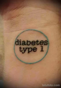 Фото простой тату с надписью 'diabetes type 1' в синем круге на руке. Минималистичная татуировка.