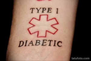 Фото тату креста скорой помощи и надписи 'Type 1 Diabetic' на руке. Черно-красная татуировка.