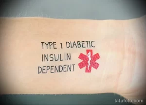 Фото тату на руке: надпись 'TYPE 1 DIABETIC INSULIN DEPENDENT' и красный медицинский крест. Информативная татуировка.