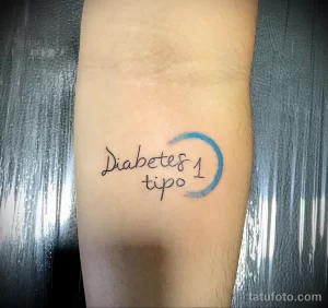 Фото татуировки с надписью 'Diabetes tipo 1' и синим полумесяцем на руке. Минималистичный стиль, четкие линии, акцент на здоровье.