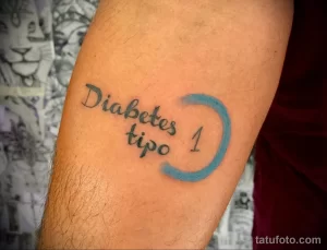 Фото тату: надпись 'Diabetes Tipo 1' и голубой круг, выполненные на руке, символизирующие борьбу с диабетом.