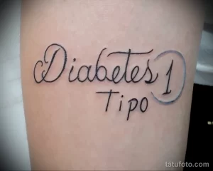 Фото тату: изящная надпись 'Diabetes Tipo 1' на руке, выполненная каллиграфическим шрифтом черными чернилами.