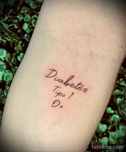 Фото тату: простая, но значимая надпись 'Diabetes Tipo 1 O+' на руке, выполненная черными чернилами.