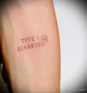 Фото минималистичной татуировки на руке с надписью "TYPE 1 (AB) DIABETES". Простой и лаконичный дизайн, выполненный тонкими линиями.
