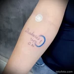 Фото татуировки диабет 1 типа на руке: надпись "Diabetes tipo 1" и "0 A+" рядом с небольшим синим кругом. Минималистичный и символичный дизайн.