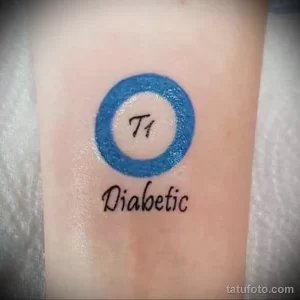 Фото тату: синий круг с надписью 'T1 Diabetic' внутри. Минималистичный стиль, небольшое изображение на запястье.
