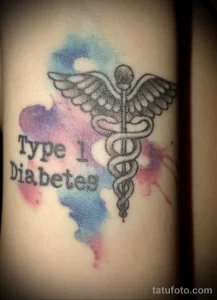 Фото тату на руке: акварельный фон с медицинским символом и надписью 'Type 1 Diabetes'. Символизирует диабет первого типа.
