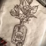 Фото эскиза тату: рисунок кофейных зерен в бутылке с надписью 'Cold Brew'. Черно-белый эскиз, графика.