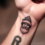 уник тату фото 6 A miniature but detailed tattoo of Ded Moroz on a person's wrist, with a focus on his traditional headwear 13.11.2023 tatufoto.com 06