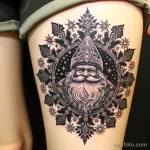 уник тату фото 9 A tattoo of Ded Moroz surrounded by snowflakes and winter patterns on a person's thigh 13.11.2023 tatufoto.com 09