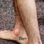 Фотография татуировки с именем 'Zayn', выполненной на стопе. Простой шрифт, черные чернила, минималистичный дизайн.