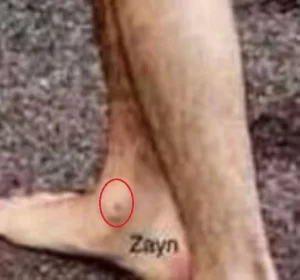 Фотография татуировки с именем 'Zayn', выполненной на стопе. Простой шрифт, черные чернила, минималистичный дизайн.