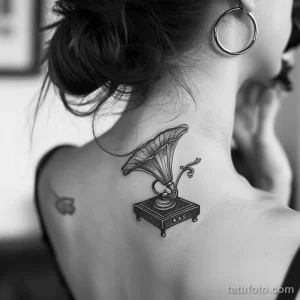Фото тату: простой и элегантный рисунок граммофона в стиле dotwork на женской шее. Черно-белый эскиз тату с тонкими линиями.