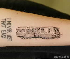 Фото тату: простой контурный рисунок автобуса с надписью 'I NEVER LOST THAT EASY' на руке.
