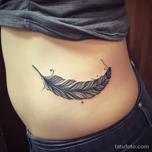 Фото тату: реалистичное изображение пера, выполненное в технике blackwork на женском боку. Элегантный рисунок татуировки.