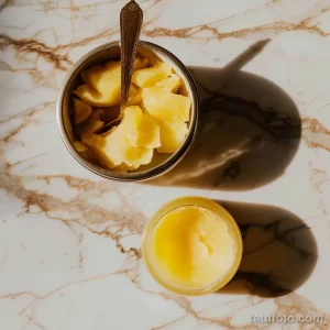 Топленое масло Гхи в керамической чаше, украшенное кусочками фруктов и ложкой. Аппетитный и полезный завтрак.