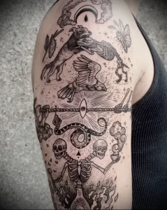 Фотография татуировки в стиле blackwork на руке, изображающей черепа, животных, глаза и другие символы. Татуировка выполнена в черном цвете с использованием точечной техники.