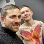 Фото татуировки на груди: яркий и красочный феникс, расправивший крылья.