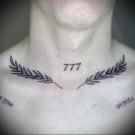 Фото тату числа 777, окруженного лавровыми ветвями. Черно-белый рисунок в стиле графика с четкими линиями.